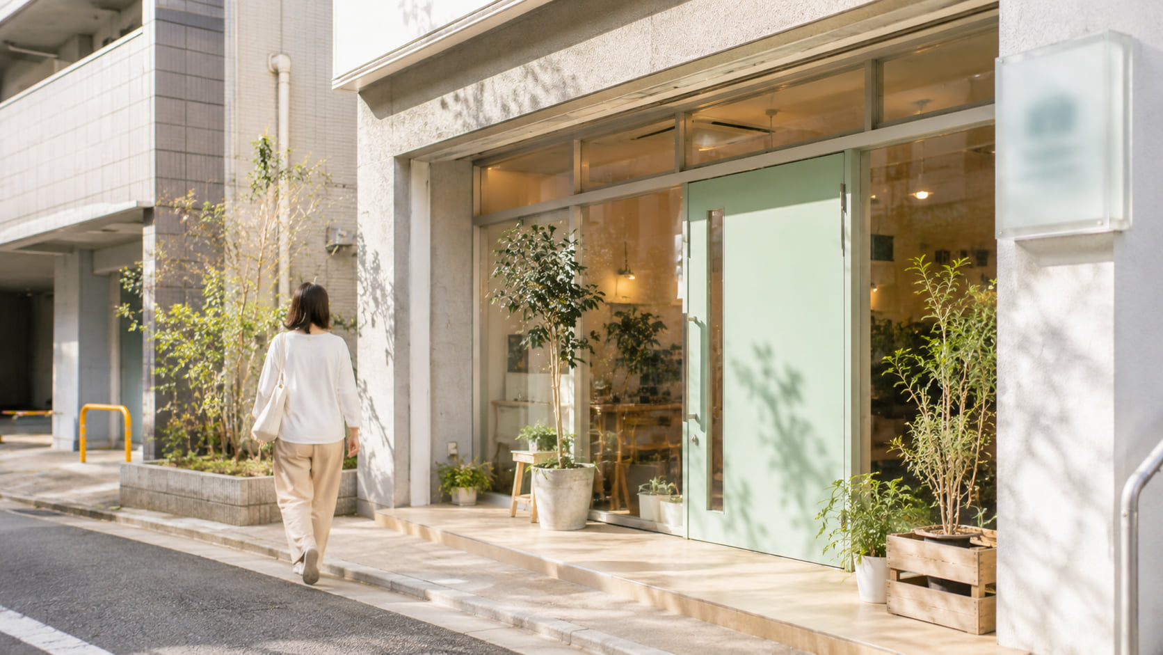 木製のテーブルで打ち合わせをする様子。マグカップ・植物・ノートが並ぶ静かな空間。