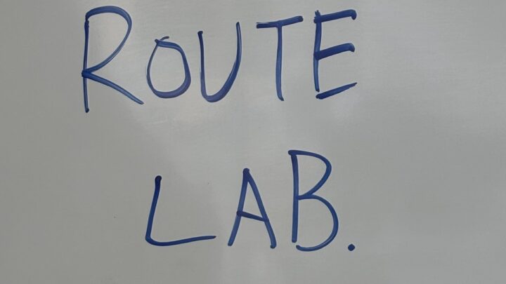 「ROUTE LAB.」と書かれたホワイトボードや黒板の文字、または授業中に使われたワークシート的なもの。スクール内の雰囲気が伝わるもの