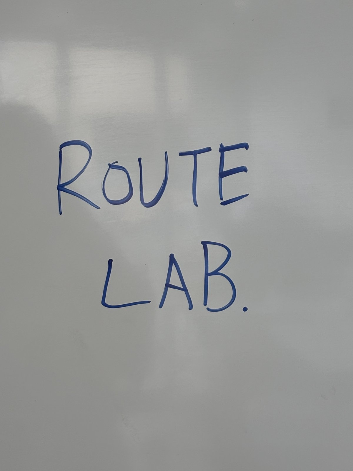 「ROUTE LAB.」と書かれたホワイトボードや黒板の文字、または授業中に使われたワークシート的なもの。スクール内の雰囲気が伝わるもの