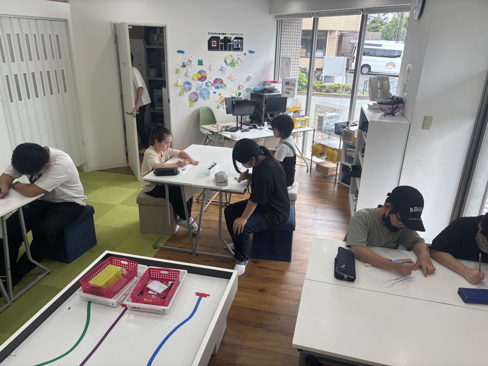 スタッフと子どもが並んで座り、和やかに話しているシーン。対話の空気感が伝わる自然な雰囲気