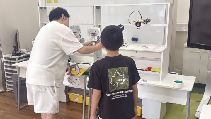 キッチンで親子が並んで朝ごはんを食べている様子。自然光。子どもの顔が映らないアングル