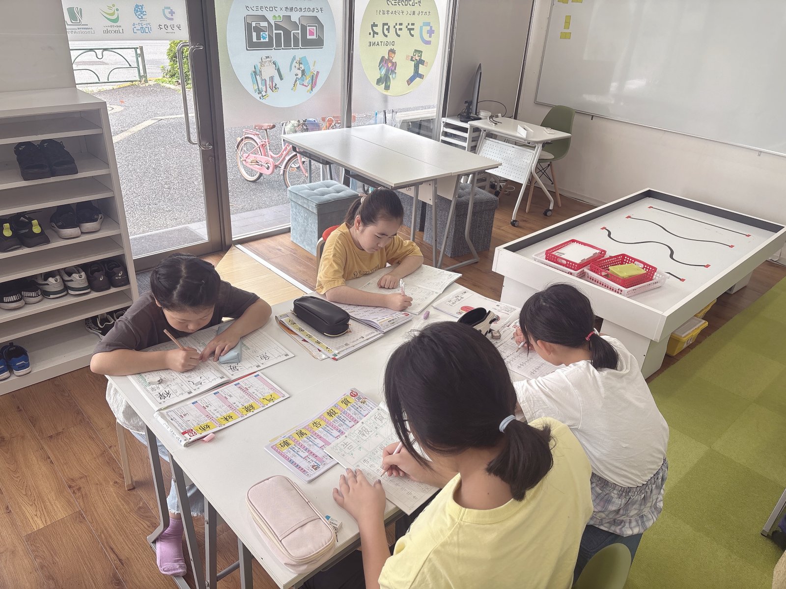 サムネイル|明るい室内で、子どもがテキストに向かいながらスタッフと穏やかに話しているシーン。温かみのある自然光が差し込んでいる写真