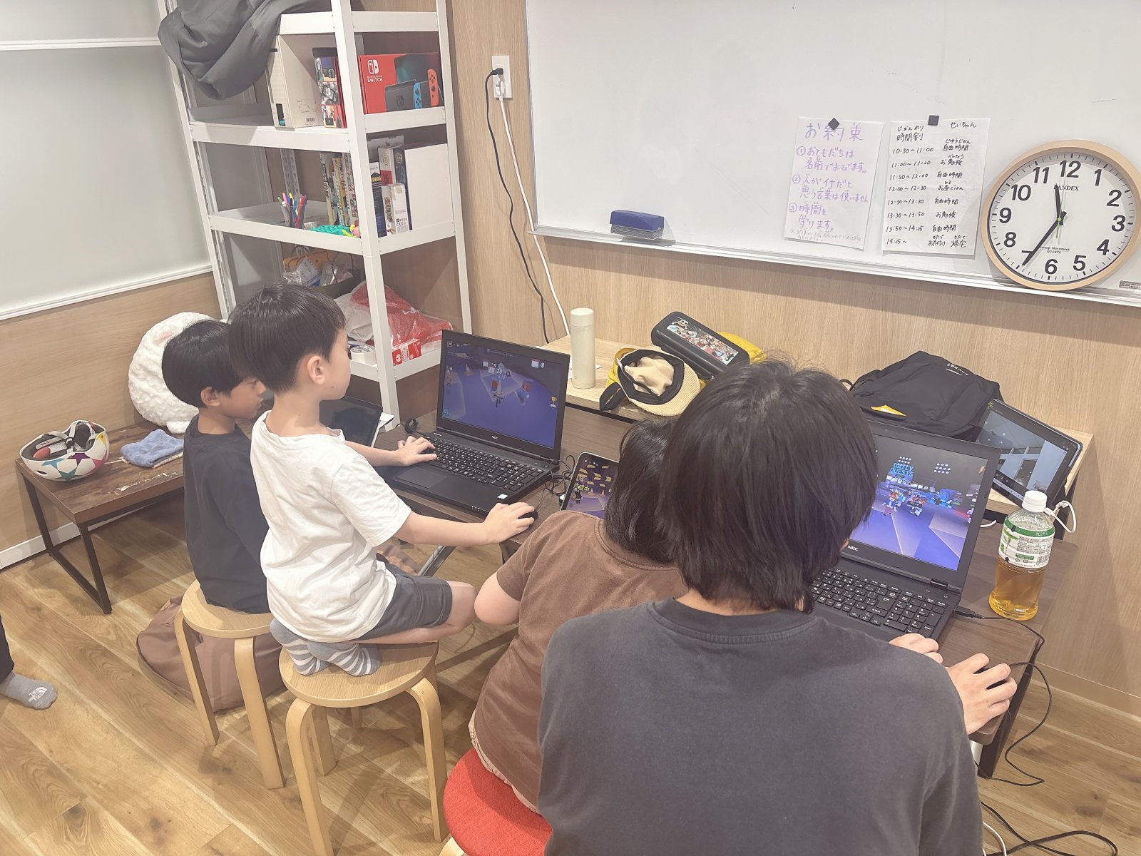 スタッフと子どもが一緒にプリントやタブレットを見ながら穏やかに学習しているシーン。「勉強させられている」ではなく「一緒に取り組んでいる」雰囲気の写真