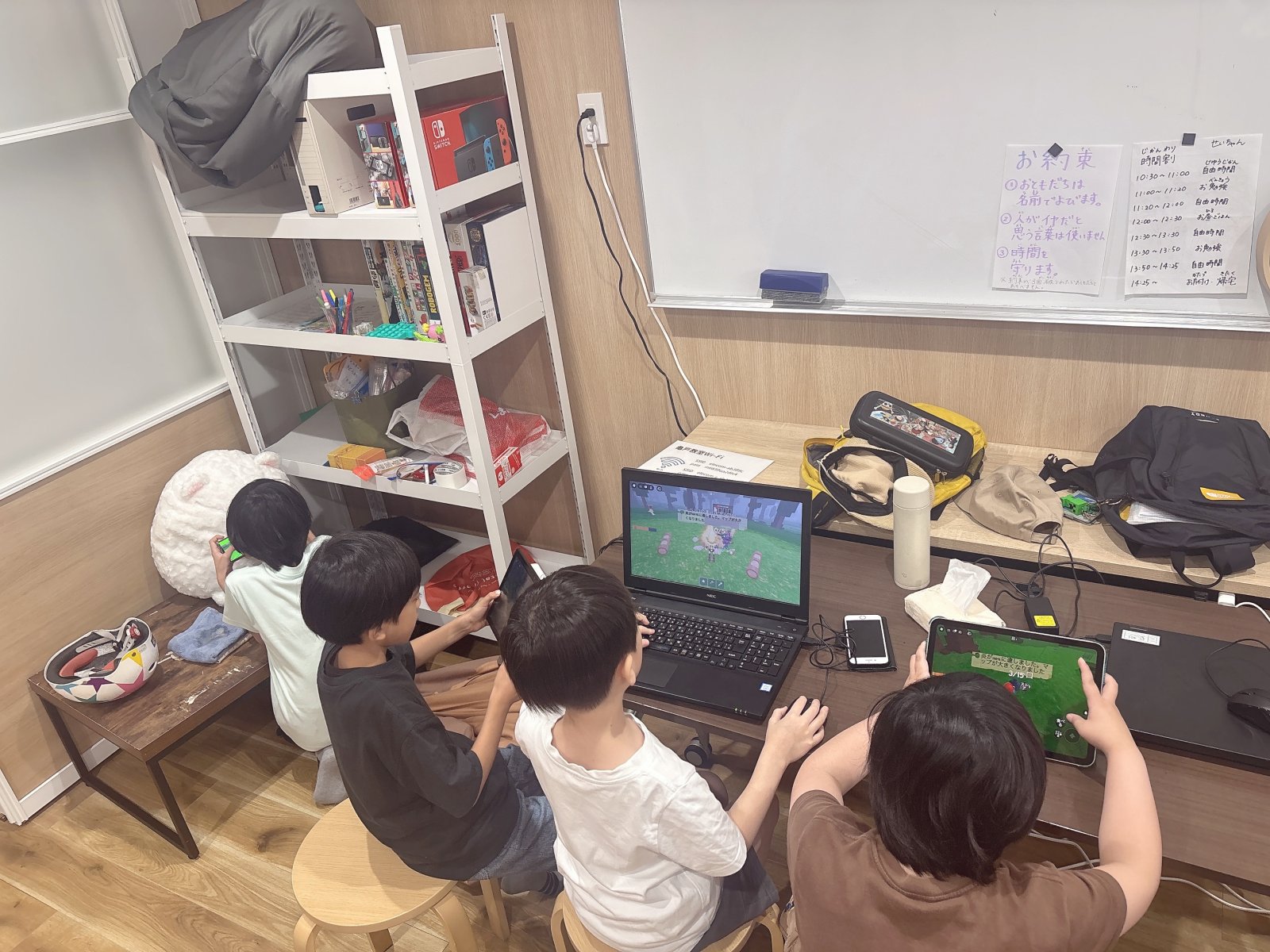 子どもがタブレットやPCの前に静かに座り、画面を見ている後ろ姿。落ち着いた雰囲気で、一人の空間が守られている様子