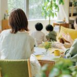 保護者同士がカフェや部屋で向き合って話している様子。リラックスした雰囲気で、「つながれる場所」のイメージ