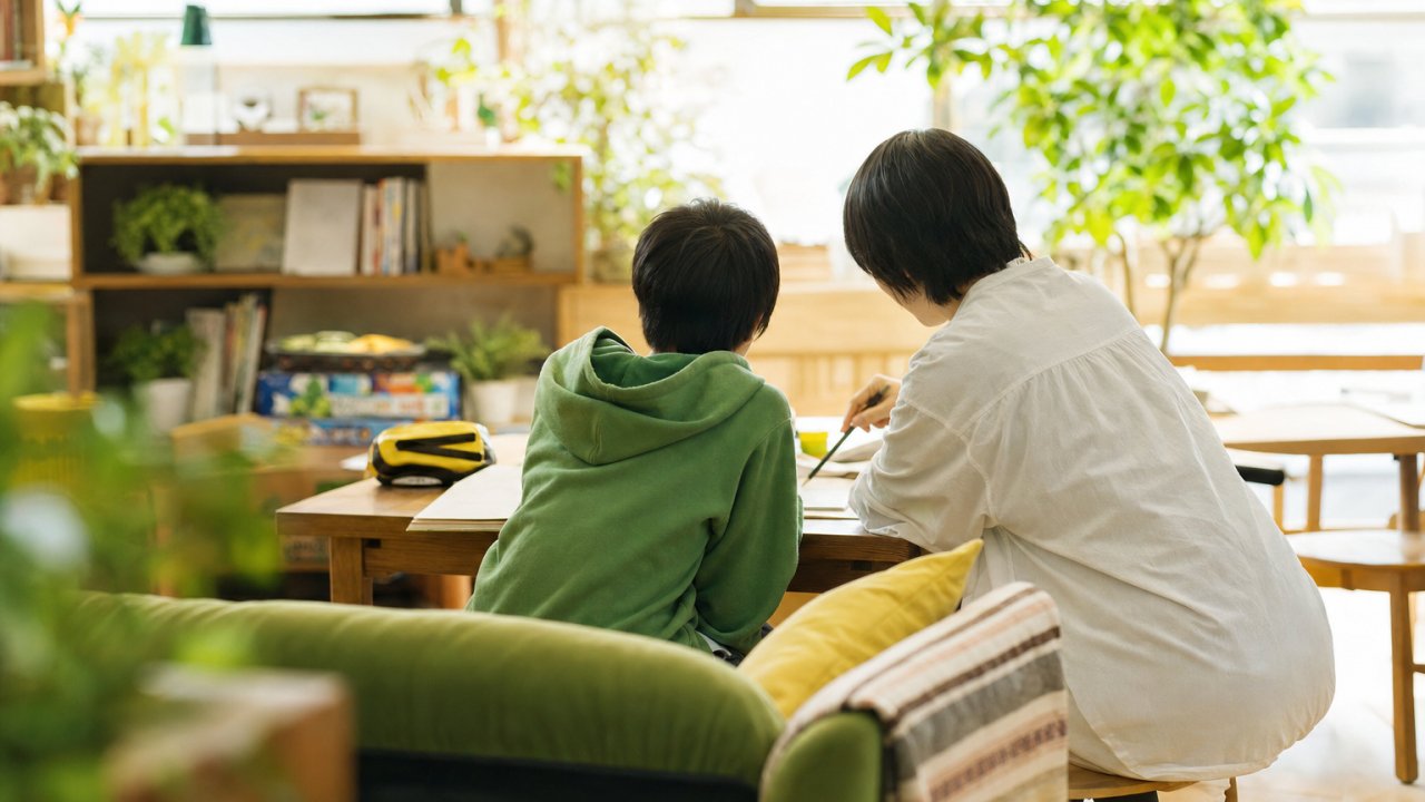 スタッフが子どもの隣に座り、穏やかに話しかけている様子。教室のような堅苦しさではなく、リビングのようなあたたかい空間で。サムネイル用メイン画像